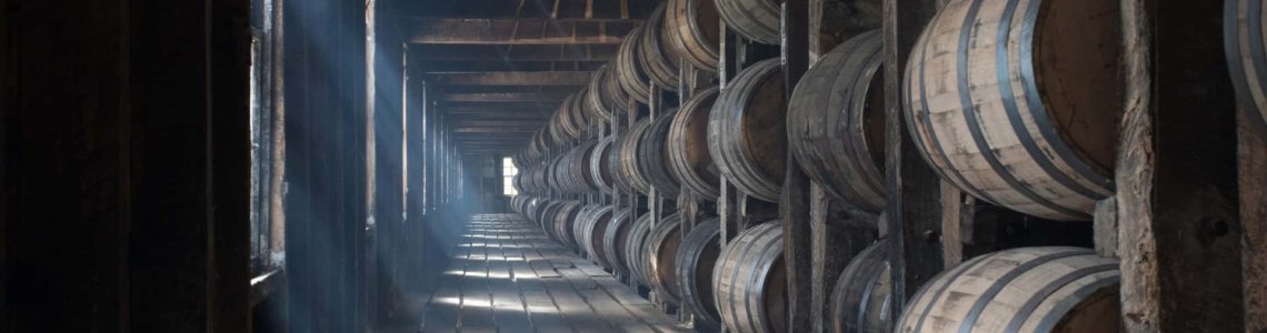 Sunlight streams through the window of a Bourbon rickhouse